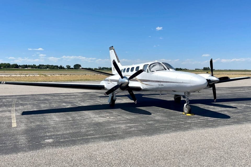 Piper Cheyenne II twin-engine turboprop aircraft parked on an airport ramp under clear skies 2