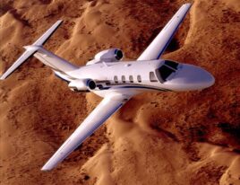Cessna Citation CJ1 jet flying above sand dunes in the desert. 4