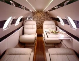 Citation CJ1 cabin interior with four leather club seats and dining setup. 4