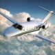 Cessna Citation CJ2 light jet flying over clouds in clear sky