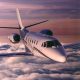Cessna Citation Excel business jet in flight over cloud layer at dusk