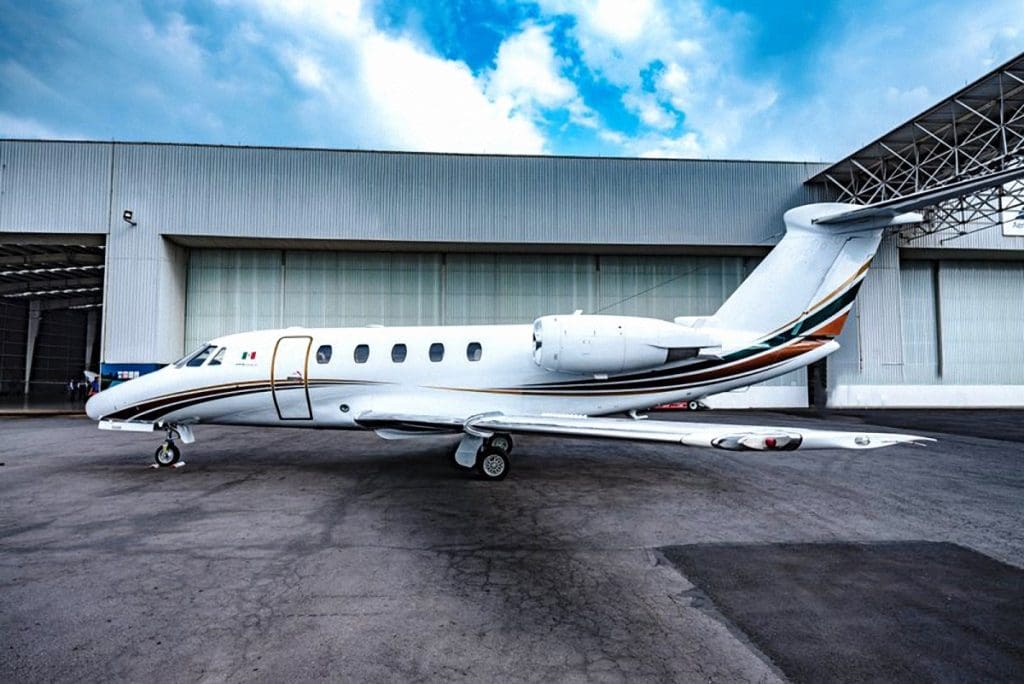 Cessna Citation VI parked outside a hangar with partly cloudy sky