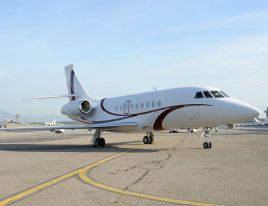 Dassault Falcon 2000LXS parked on the ramp at a busy airport.