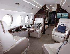 Private jet cabin with cream leather recliner seats and work tables