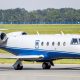 Gulfstream G150 private jet taxiing on a runway at an airport.