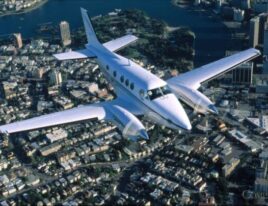 King Air C90B flying above a densely populated cityscape