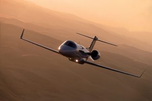 Learjet 45XR in flight during golden hour over desert terrain