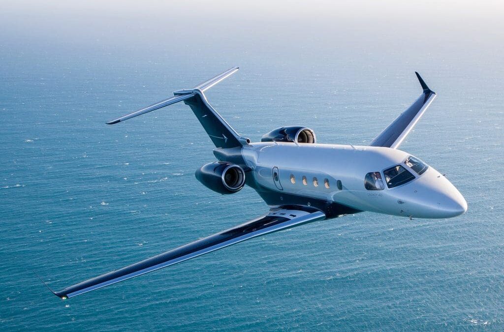 Embraer Legacy 450 private jet flying over the ocean