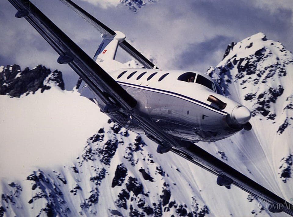 Pilatus PC-12 NGX flying over snow-covered mountain range