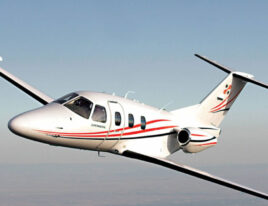 Eclipse EA500 light jet in mid-flight with red and white stripes.
