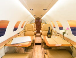 Citation Ultra jet cabin table setup with laptop and wine