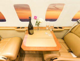 Close-up of Citation Ultra seat-side table with champagne and flowers