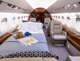 Falcon 2000LX cabin interior with lie-flat bed, luxurious bedding, and leather seating