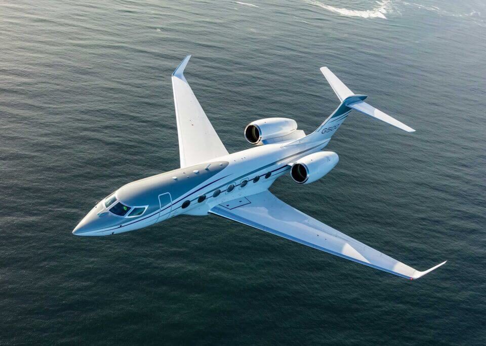 Luxury business jet flying over the ocean on a clear day