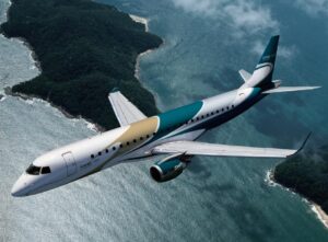 Embraer Lineage 1000 flying over a tropical coastline