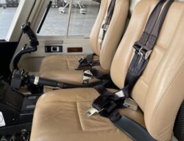 Dual cockpit seats in 1999 Bell 407 helicopter with tan leather and flight controls