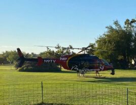 SkyNews-liveried 1999 Bell 407 helicopter parked on grassy field in daylight