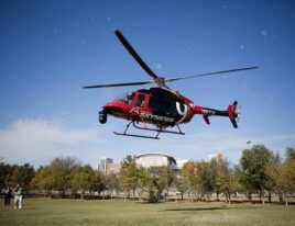 1999 Bell 407 helicopter hovering over grassy field during daytime