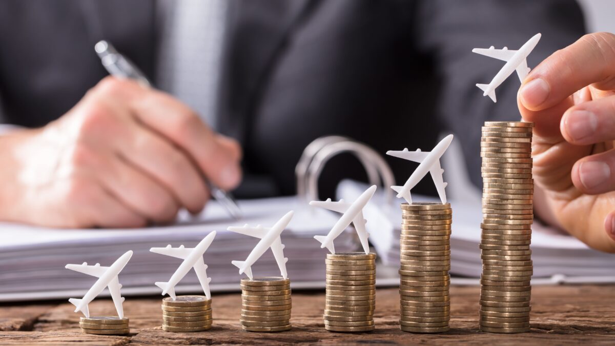 Miniature airplanes placed on stacked coins representing aircraft value growth and financial planning