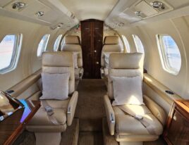 1984 Citation III interior forward cabin view with beige leather seats and wood accents