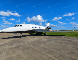 2002 Dassault Falcon 2000 business jet parked on an airport ramp under a blue sky.
