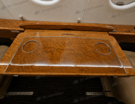 2002 Dassault Falcon 2000 cabin conference table with high-gloss wood veneer and executive seating.
