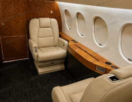 2002 Dassault Falcon 2000 aft cabin with cream leather executive seating and high-gloss wood veneer cabinetry.